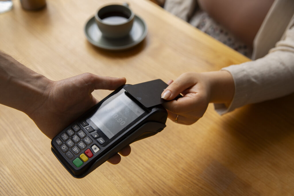 A customer pays with their credit card at a portable card payment terminal.

