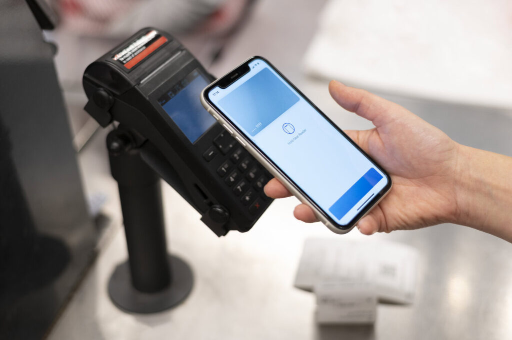 A person pays with their e-wallet app at a card payment terminal.