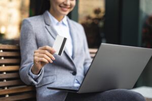 A smiling businesswoman conducts a transaction online via an online payment system in Malaysia.