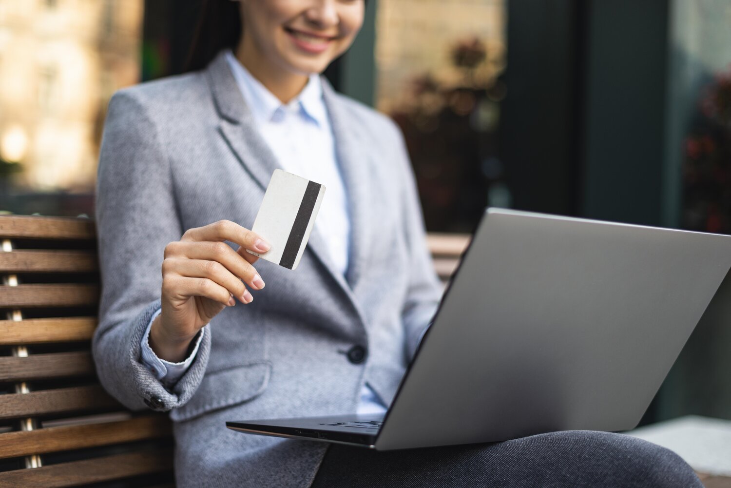 A smiling businesswoman conducts a transaction online via an online payment system in Malaysia.