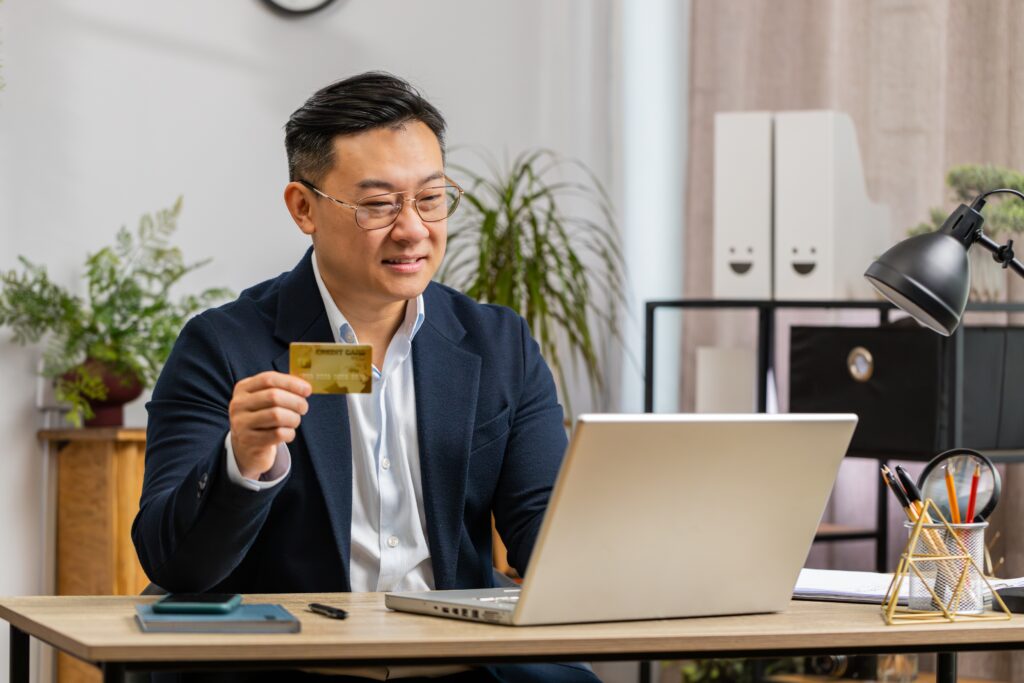 A middle-aged software developer testing a subscription payment gateway with a credit card.