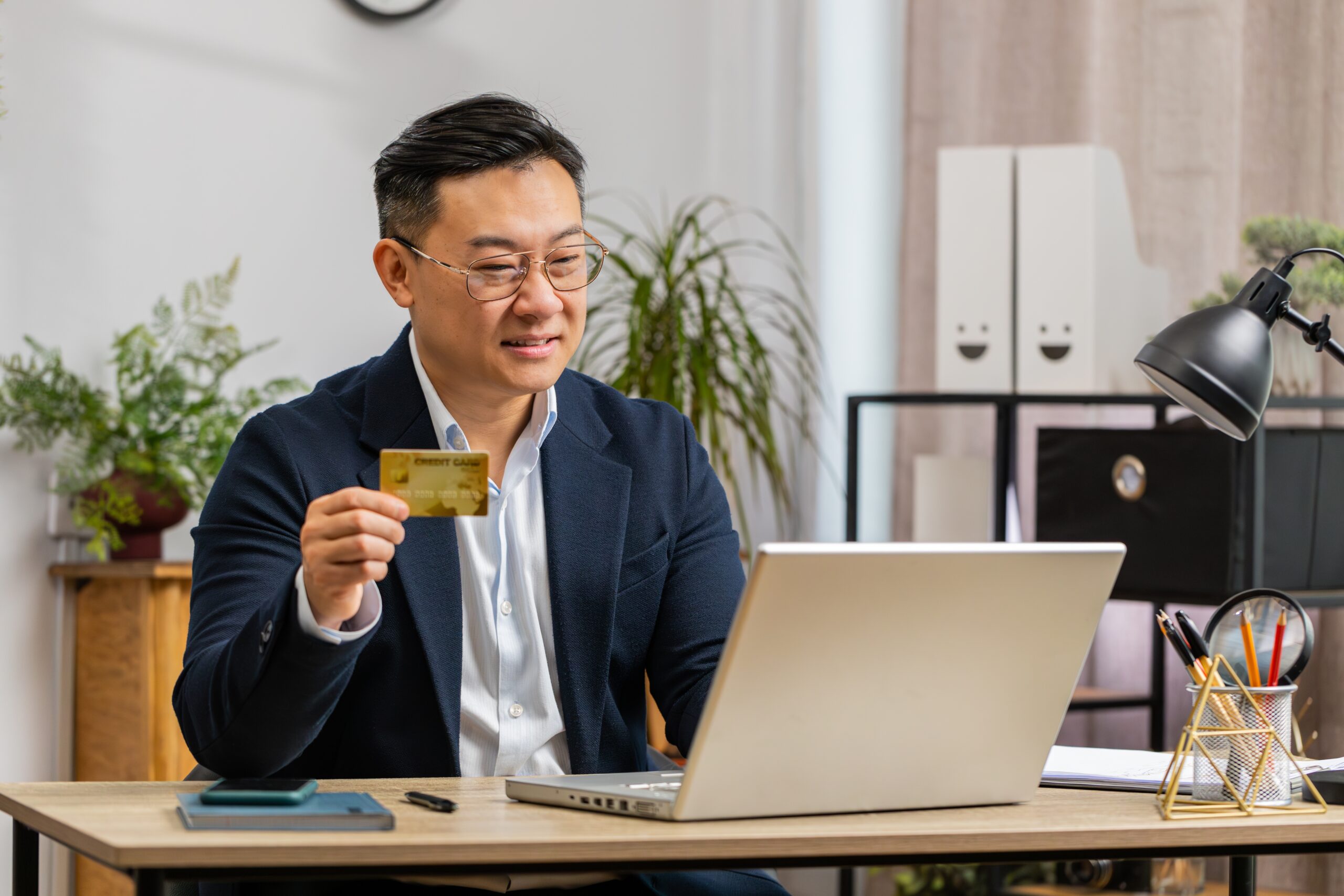 A middle-aged software developer testing a subscription payment gateway with a credit card.