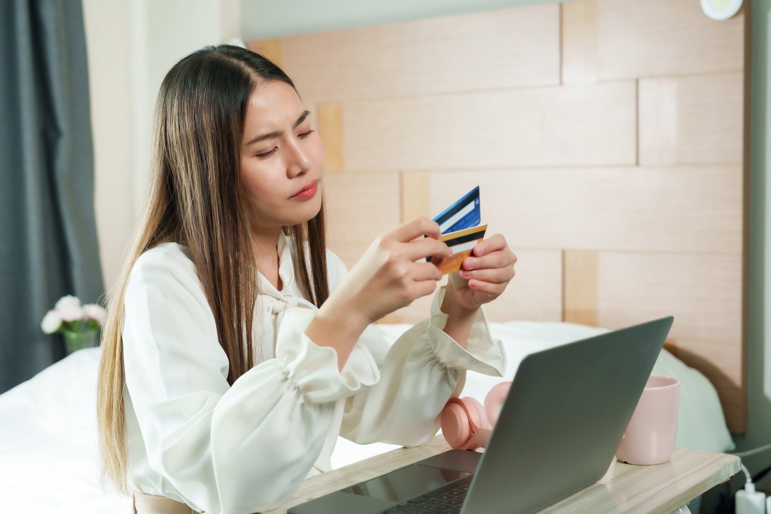 A woman holds her credit cards for online payment. A good payment page matters for online sales.