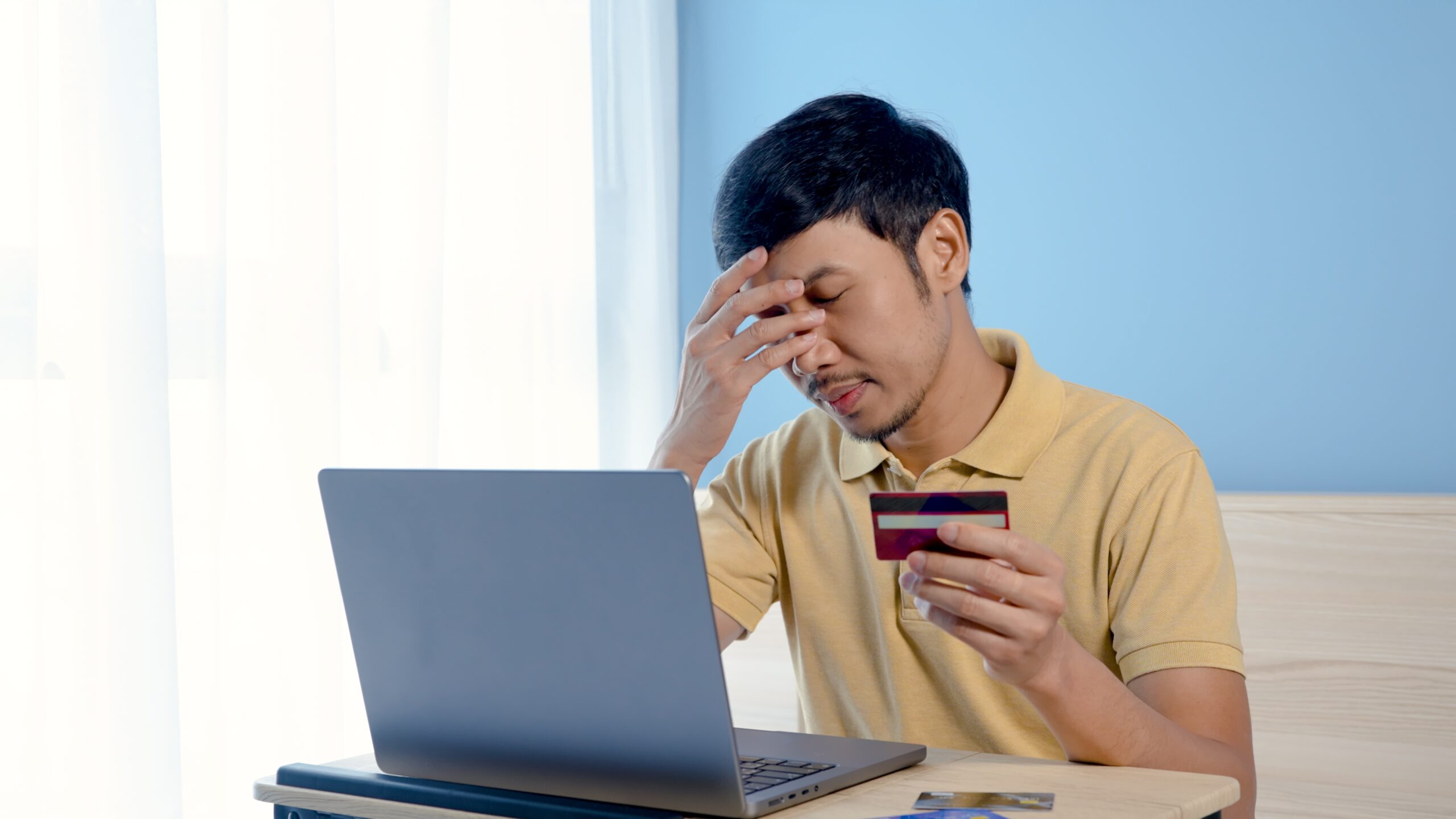 A customer hesitates, holding his credit card. Payment pages must feel congruent with your brand.