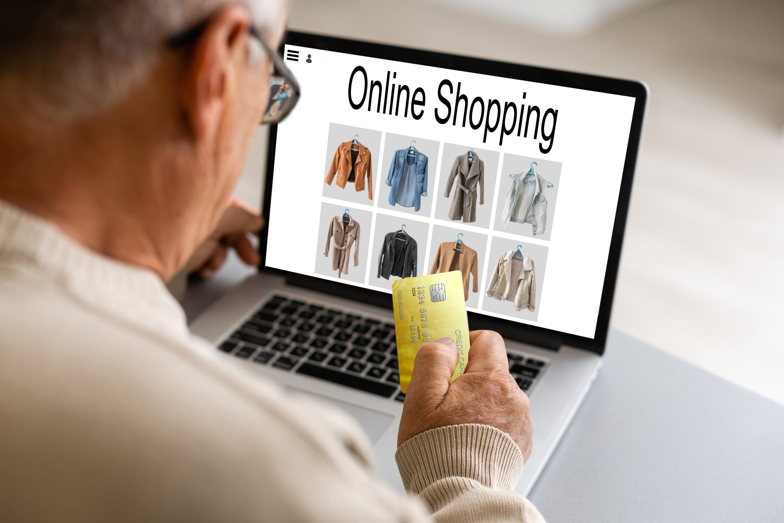 Customer viewing an online clothing store on laptop with credit card in hand