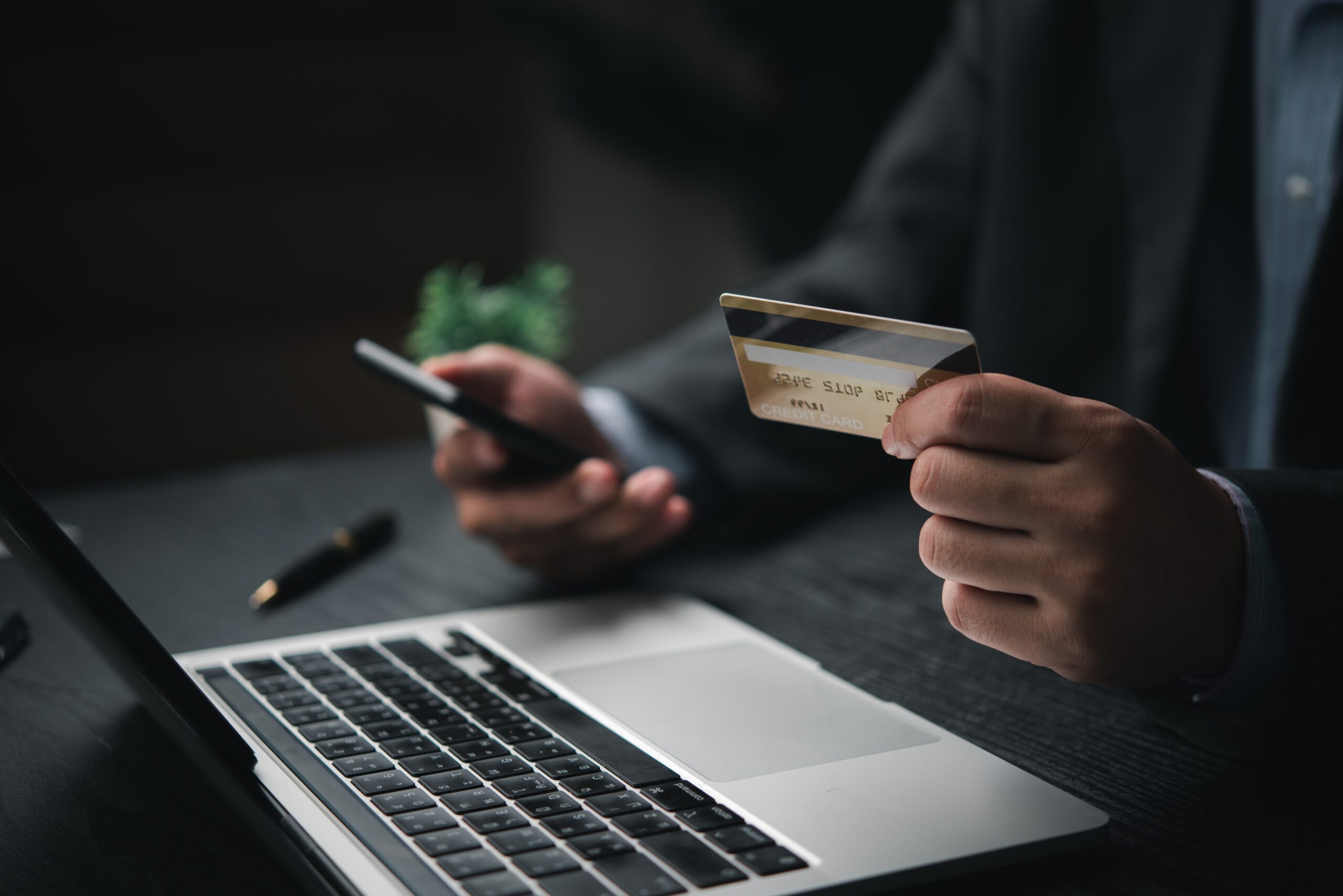 Business professional using credit card and smartphone to complete a secure online payment
