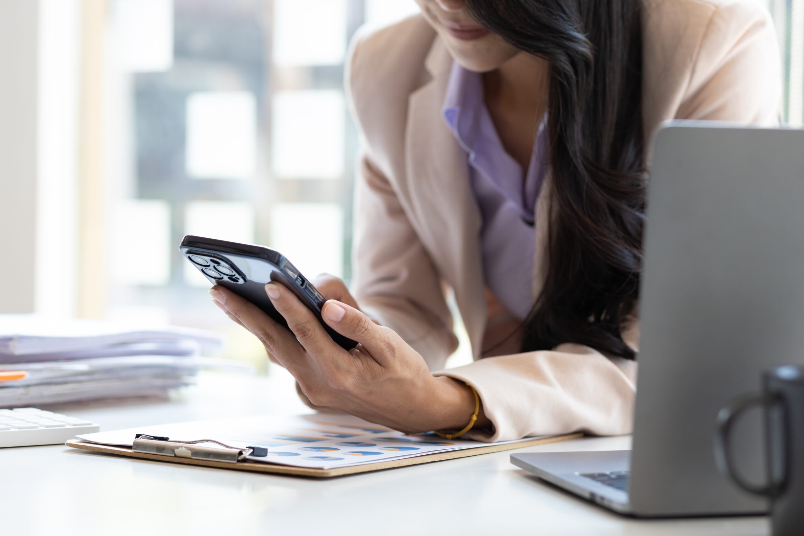A business owner testing a payment button on a mobile phone in Malaysia.